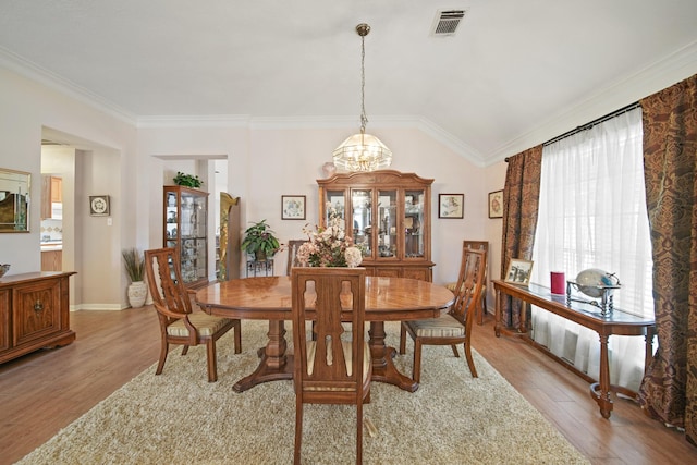 1512 Pine Ridge Ln, Pearland, TX 77581 - dining room with light wood finished floors, a chandelier, ornamental molding, and vaulted ceiling