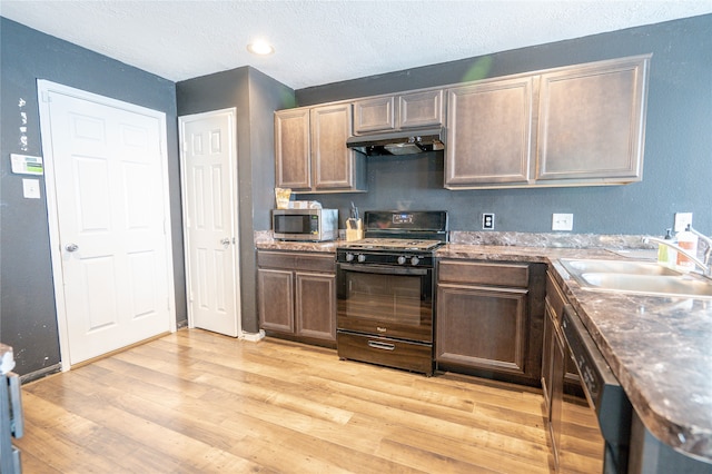 1119 Grassy View Dr, Houston, TX 77073 - kitchen featuring black range with gas cooktop, under cabinet range hood, stainless steel microwave, light wood finished floors, and dishwasher