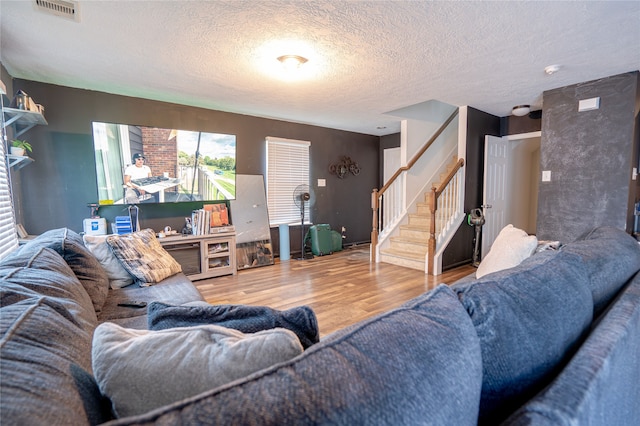 1119 Grassy View Dr, Houston, TX 77073 - living room with stairway, wood finished floors, and a textured ceiling