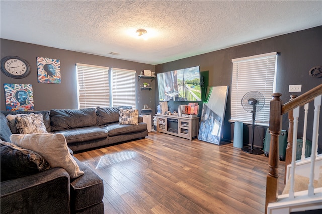 1119 Grassy View Dr, Houston, TX 77073 - living room featuring wood finished floors, a textured ceiling, and stairs