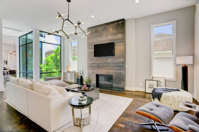 5007 Dickson St, Houston, TX 77007 - living room featuring a chandelier, recessed lighting, wood finished floors, a fireplace, and an accent wall