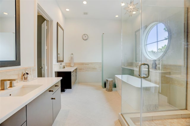 5007 Dickson St, Houston, TX 77007 - full bath featuring two vanities, a freestanding tub, a stall shower, recessed lighting, and tile patterned flooring
