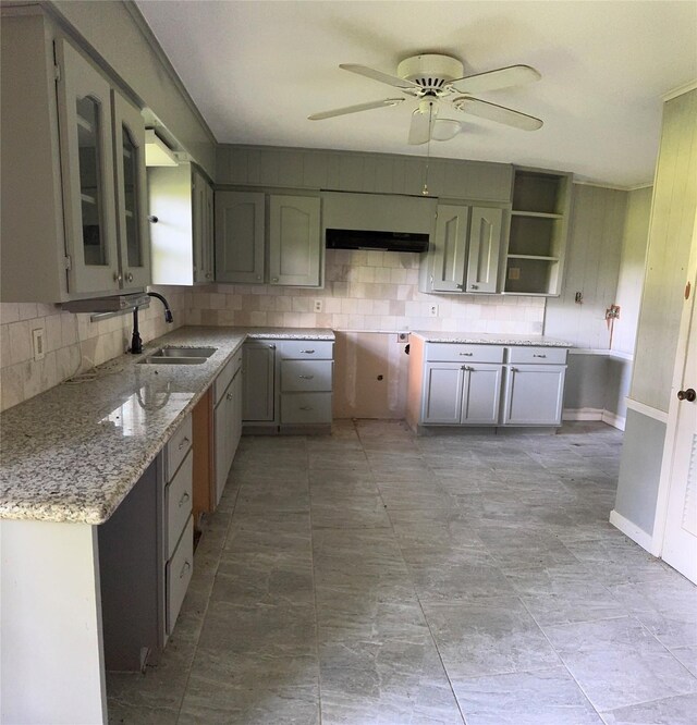 3120 Cemetery Rd, Santa Fe, TX 77517 - kitchen with decorative backsplash, ventilation hood, ceiling fan, light stone countertops, and glass insert cabinets