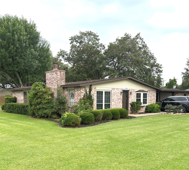 103 Greenbriar Dr, Wharton, TX 77488 - view of front of home with a chimney, a front yard, and brick siding