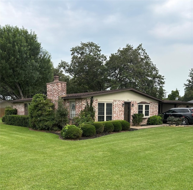 103 Greenbriar Dr, Wharton, TX 77488 - view of front of home featuring a chimney, brick siding, and a front lawn