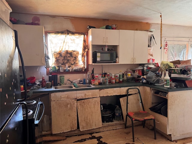 21269 Bracewell Rd, Bedias, TX 77831 - kitchen featuring black appliances, plenty of natural light, backsplash, white cabinets, and a textured ceiling