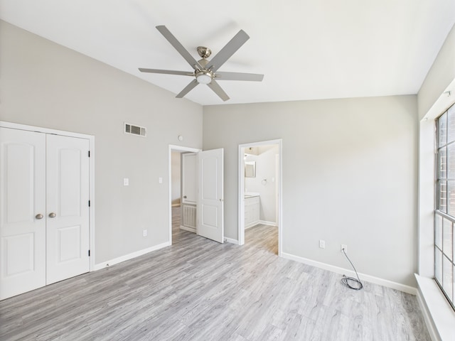 8055 Cambridge St Unit 26, Houston, TX 77054 - unfurnished bedroom with vaulted ceiling, a closet, light wood-type flooring, a ceiling fan, and ensuite bathroom