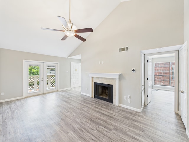 8055 Cambridge St Unit 26, Houston, TX 77054 - unfurnished living room featuring high vaulted ceiling, ceiling fan, light wood-style flooring, a fireplace, and french doors