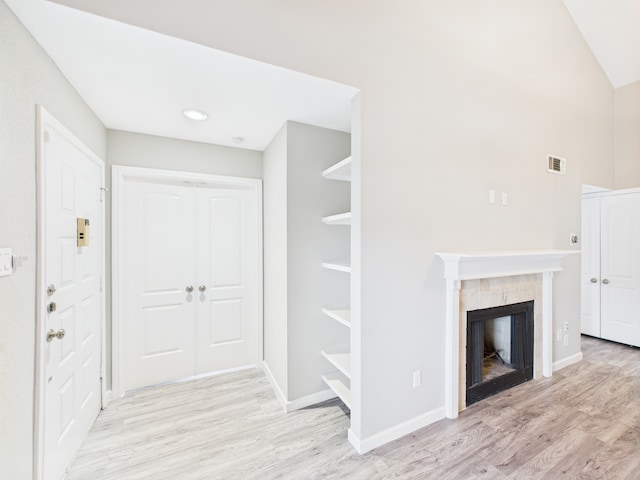 8055 Cambridge St Unit 26, Houston, TX 77054 - unfurnished living room with light wood-style floors and a tiled fireplace
