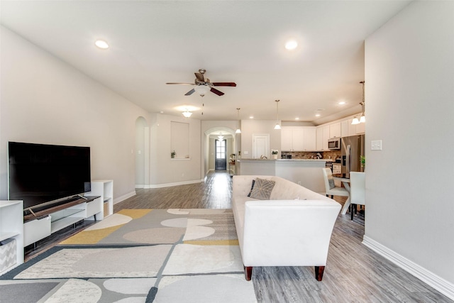 3053 Peterson Cir, Bryan, TX 77802 - living area featuring arched walkways, light wood-style flooring, a ceiling fan, and recessed lighting