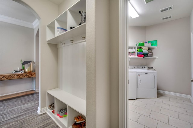 3053 Peterson Cir, Bryan, TX 77802 - mudroom featuring arched walkways, washing machine and clothes dryer, crown molding, and light tile patterned floors