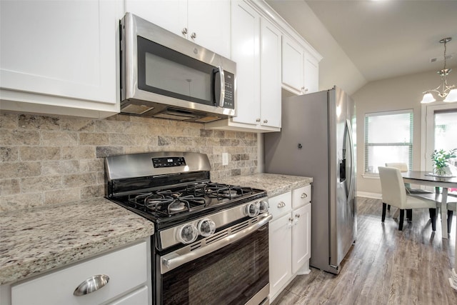 3053 Peterson Cir, Bryan, TX 77802 - kitchen featuring appliances with stainless steel finishes, light wood-type flooring, a chandelier, white cabinets, and backsplash
