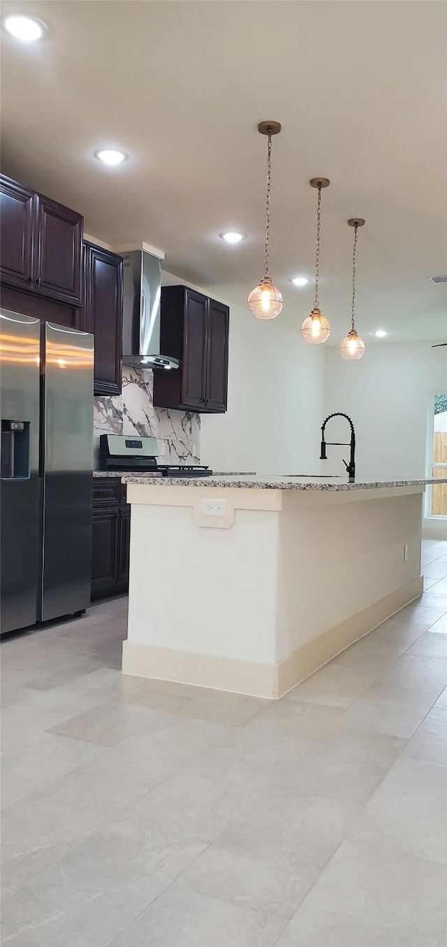 4209 Tampico Rd, Houston, TX 77016 - kitchen with stainless steel fridge, wall chimney exhaust hood, backsplash, hanging light fixtures, and light stone countertops