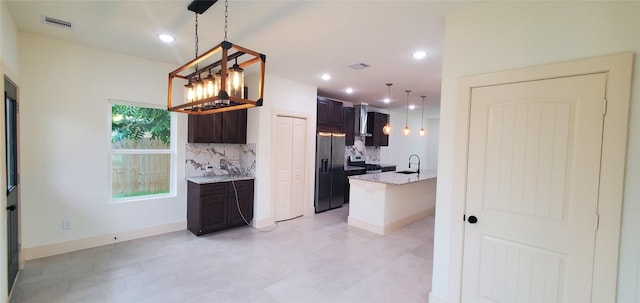 4209 Tampico Rd, Houston, TX 77016 - kitchen featuring refrigerator with ice dispenser, tasteful backsplash, dark brown cabinets, light stone counters, and light flooring