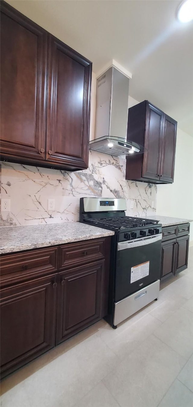 4209 Tampico Rd, Houston, TX 77016 - kitchen with stainless steel gas range, wall chimney range hood, tasteful backsplash, and dark brown cabinets