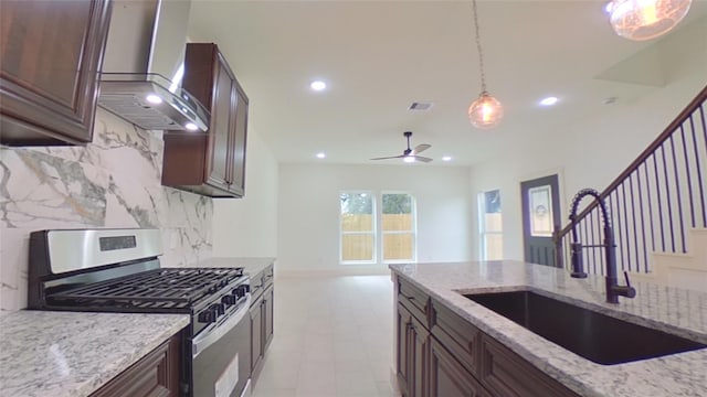 4209 Tampico Rd, Houston, TX 77016 - kitchen featuring stainless steel range with gas cooktop, wall chimney range hood, decorative backsplash, pendant lighting, and recessed lighting