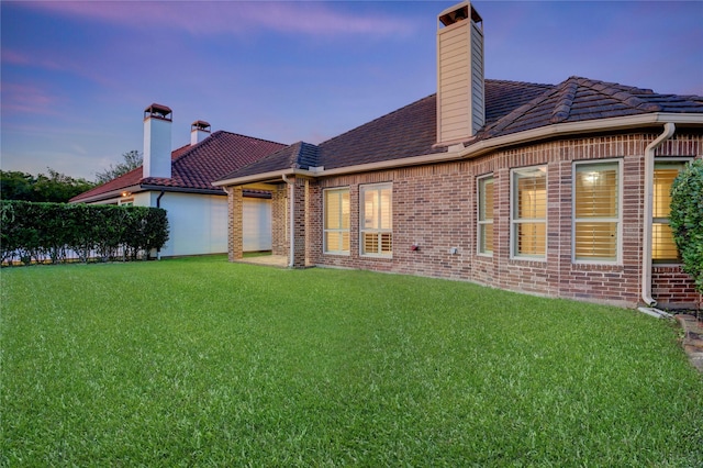 4023 Turning Manor Ln, Sugar Land, TX 77479 - back of property with brick siding, a yard, and a chimney