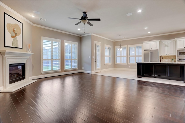 4023 Turning Manor Ln, Sugar Land, TX 77479 - unfurnished living room featuring a ceiling fan, a glass covered fireplace, wood finished floors, crown molding, and recessed lighting