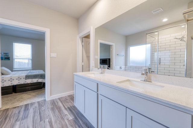 10026 Angelina Woods Ln, Conroe, TX 77384 - full bathroom with a stall shower, wood finished floors, double vanity, and ensuite bath