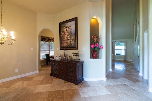22110 Nobles Crossing Dr, Spring, TX 77373 - corridor with arched walkways, a chandelier, light stone finish flooring, and a high ceiling