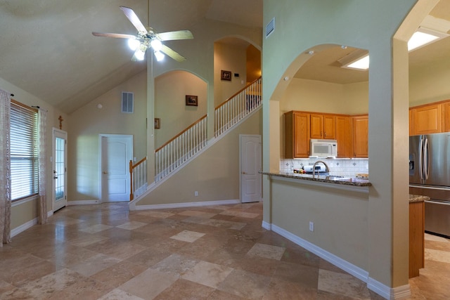 22110 Nobles Crossing Dr, Spring, TX 77373 - kitchen featuring white microwave, stainless steel fridge, high vaulted ceiling, ceiling fan, and backsplash