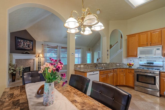 22110 Nobles Crossing Dr, Spring, TX 77373 - kitchen featuring white appliances, lofted ceiling, a chandelier, decorative backsplash, and stone counters