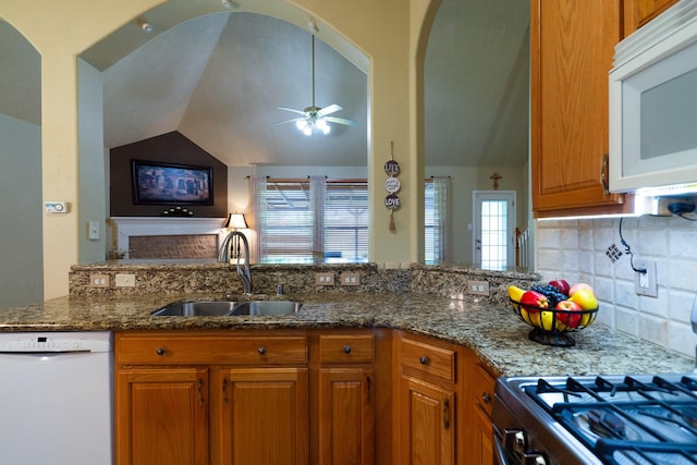 22110 Nobles Crossing Dr, Spring, TX 77373 - kitchen featuring white appliances, lofted ceiling, a ceiling fan, brown cabinets, and dark stone counters