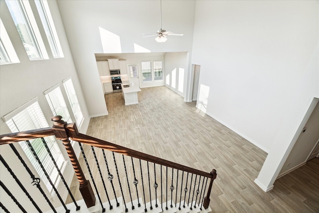 7838 Ruth Ravine Ct, Spring, TX 77379 - stairway with a towering ceiling, wood finished floors, and ceiling fan
