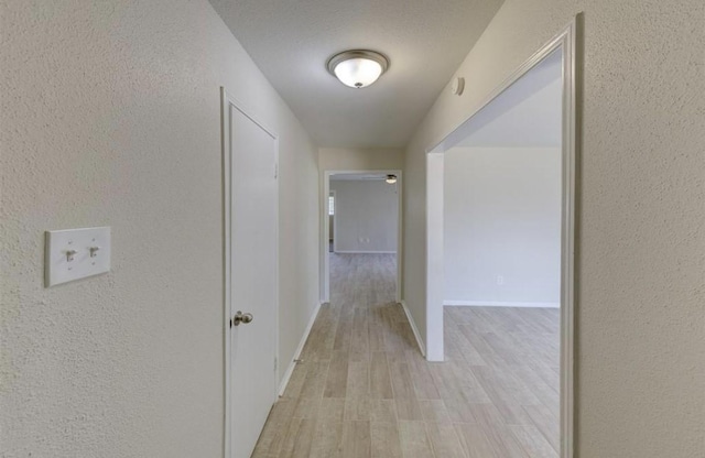 12938 S Coast Dr, Houston, TX 77047 - hallway featuring light wood-style floors and a textured wall