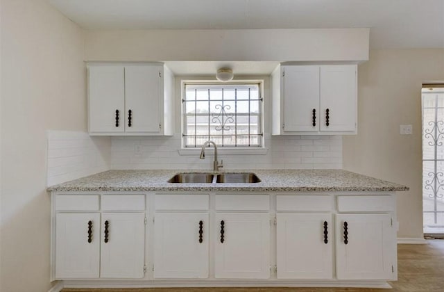 12938 S Coast Dr, Houston, TX 77047 - kitchen featuring white cabinets, tasteful backsplash, and light stone counters