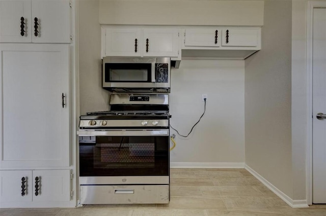 12938 S Coast Dr, Houston, TX 77047 - kitchen featuring appliances with stainless steel finishes, white cabinetry, and light wood-type flooring