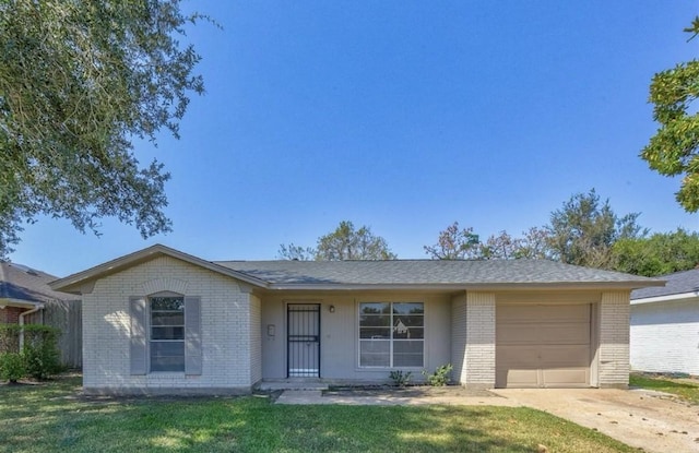 12938 S Coast Dr, Houston, TX 77047 - ranch-style house with brick siding, a garage, driveway, and a front lawn