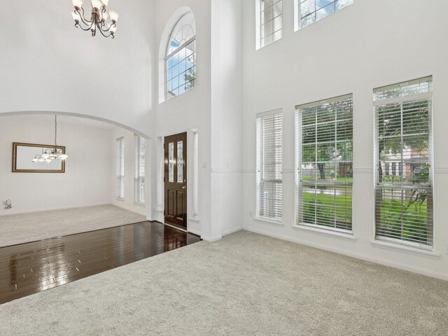 421 White Oak Pointe, League City, TX 77573 - carpeted entryway with a chandelier, a high ceiling, arched walkways, and wood finished floors
