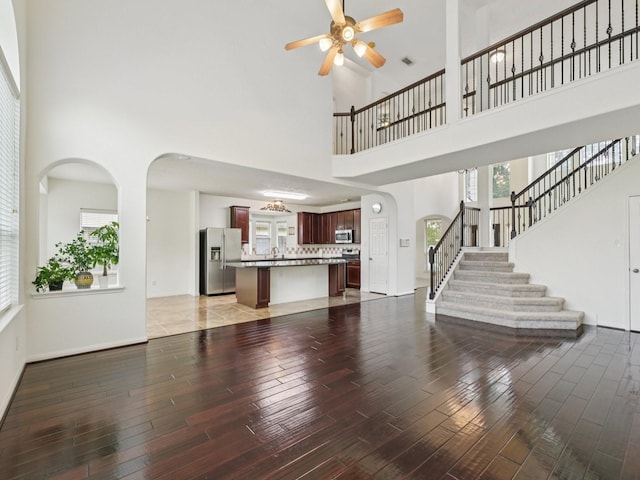 421 White Oak Pointe, League City, TX 77573 - living area featuring ceiling fan, wood finished floors, a towering ceiling, plenty of natural light, and stairs