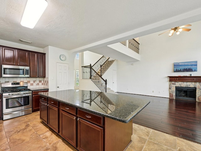 421 White Oak Pointe, League City, TX 77573 - kitchen featuring appliances with stainless steel finishes, a textured ceiling, open floor plan, ceiling fan, and tasteful backsplash