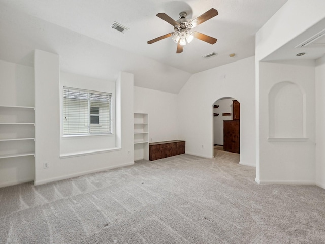 421 White Oak Pointe, League City, TX 77573 - unfurnished living room featuring arched walkways, carpet, ceiling fan, built in shelves, and lofted ceiling