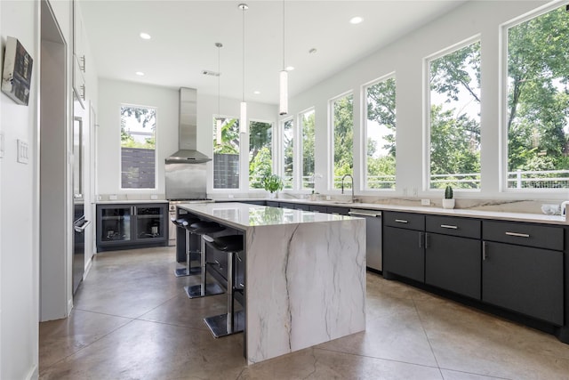 543 Threlkeld St, Houston, TX 77007 - kitchen featuring wall chimney range hood, dishwasher, a center island, recessed lighting, and a kitchen bar