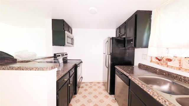 10001 Westpark Dr Unit 29, Houston, TX 77042 - kitchen featuring appliances with stainless steel finishes, dark cabinets, and light floors