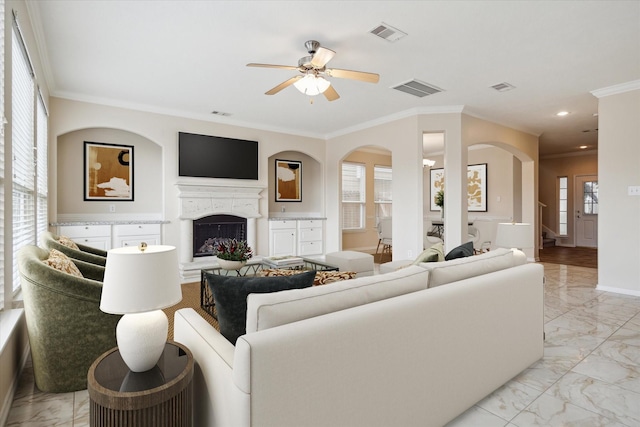 2439 Chuckberry St, Houston, TX 77080 - living room featuring light marble finish floors, arched walkways, a fireplace with raised hearth, crown molding, and a ceiling fan