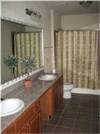 1711 Old Spanish Trl Unit 343, Houston, TX 77054 - full bath featuring double vanity, tile patterned floors, and a shower with curtain