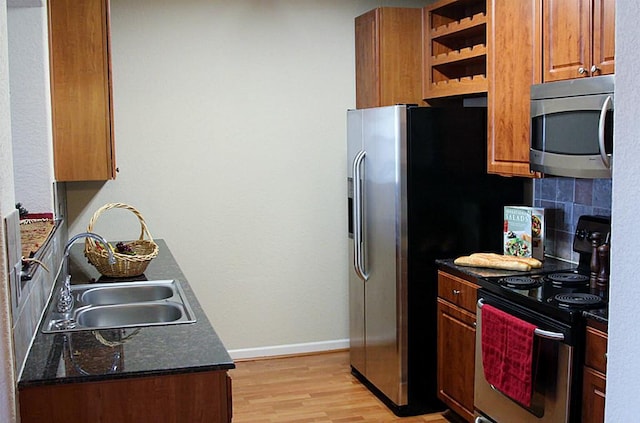 1711 Old Spanish Trl Unit 343, Houston, TX 77054 - kitchen featuring stainless steel appliances, light wood-style floors, tasteful backsplash, brown cabinets, and open shelves