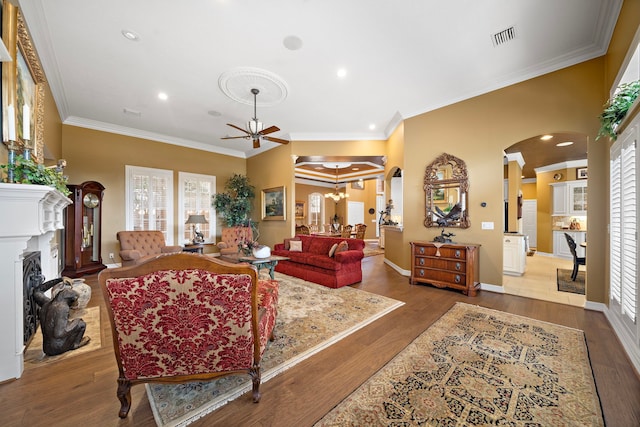 1310 Whispering Pines Dr, Houston, TX 77055 - living room featuring arched walkways, a chandelier, crown molding, a fireplace, and recessed lighting