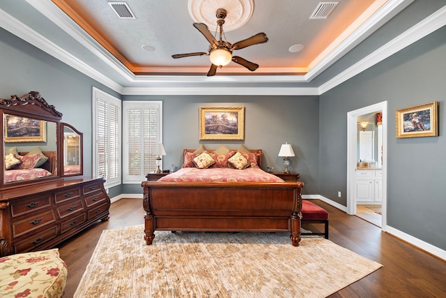 1310 Whispering Pines Dr, Houston, TX 77055 - bedroom featuring a tray ceiling, ornamental molding, dark wood finished floors, ensuite bath, and ceiling fan