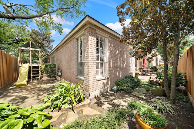 1310 Whispering Pines Dr, Houston, TX 77055 - view of home's exterior featuring brick siding, a patio, and a playground