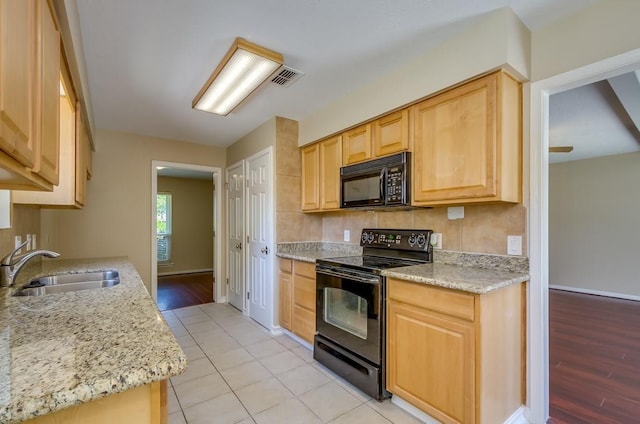 15622 Sunset Rock Dr, Houston, TX 77084 - kitchen with black appliances, light brown cabinets, backsplash, and light stone counters