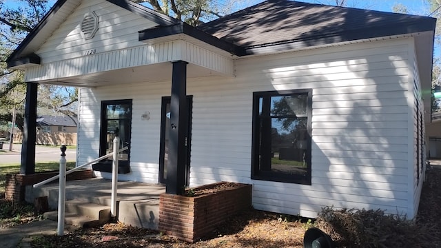 1120 W Robinson St, Alvin, TX 77511 - doorway to property with roof with shingles and a porch