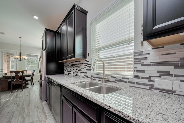 11023 Honey Suckle Haven Dr, Cypress, TX 77433 - kitchen with appliances with stainless steel finishes, backsplash, light stone countertops, a chandelier, and recessed lighting
