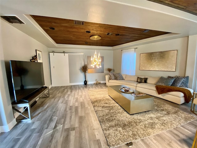 3359 Ozark St, Houston, TX 77021 - living area featuring a tray ceiling, wood ceiling, wood finished floors, a barn door, and a chandelier