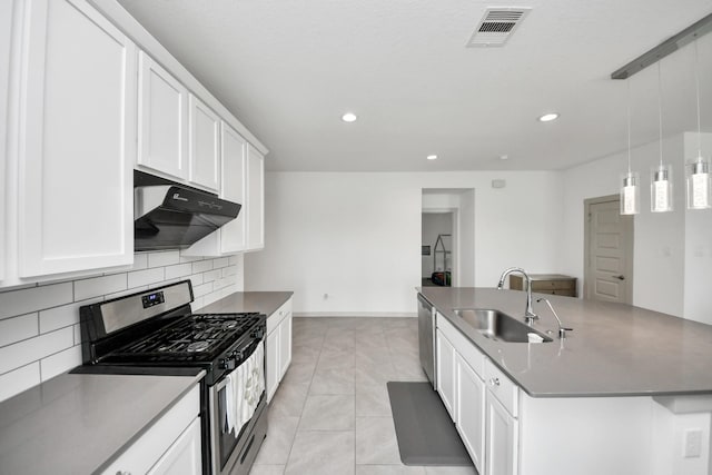 29506 Hartman Holw, Katy, TX 77494 - kitchen with appliances with stainless steel finishes, under cabinet range hood, backsplash, white cabinets, and a kitchen island with sink