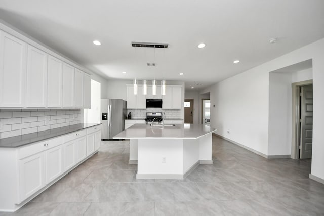 29506 Hartman Holw, Katy, TX 77494 - kitchen with stainless steel fridge with ice dispenser, decorative backsplash, recessed lighting, gas range oven, and an island with sink